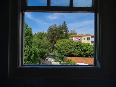 a window with a view of trees and buildings at O2 Hostel in Porto