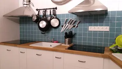 a kitchen with a sink and utensils on the wall at O2 Hostel in Porto