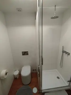a white bathroom with a shower and a toilet at O2 Hostel in Porto