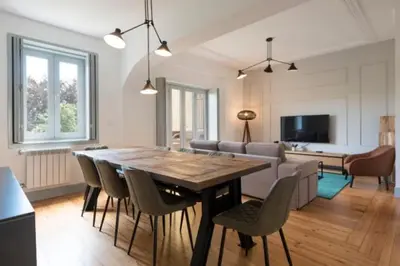 a dining room and living room with a table and chairs at Douro Central in Porto