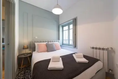 a bedroom with a large bed with two towels on it at Douro Central in Porto
