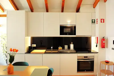 a kitchen with white cabinets and black appliances at PORTO SWEETHEART - Ricardo Jorge in Porto