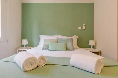 a bedroom with a large bed with towels on it at Petit Suites by PCALE in Porto