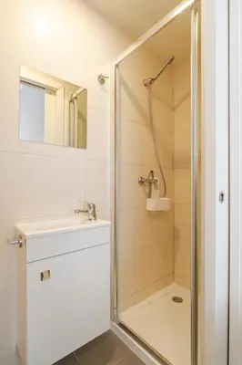a shower with a glass door in a bathroom at Petit Suites by PCALE in Porto