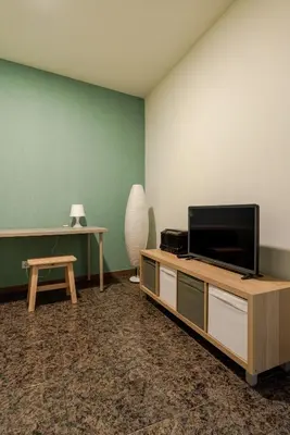 a living room with a tv and a table at Petit Suites by PCALE in Porto