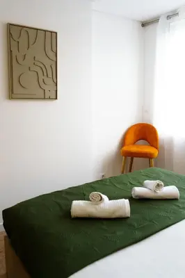 two towels on a bed in a room with a chair at Green Universe Porto by MyMoradia in Porto