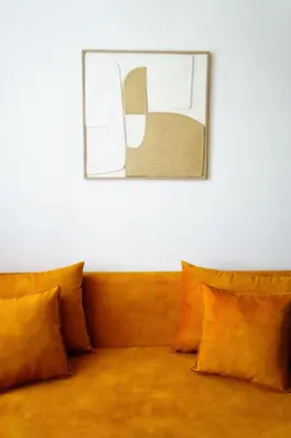 a couch with orange pillows and a picture on the wall at Green Universe Porto by MyMoradia in Porto