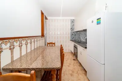 a kitchen with a table and a refrigerator at Gaia Family Nest in Vila Nova de Gaia