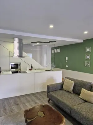 a living room with a couch and a kitchen at Campanhã Clock House with terrace in Porto