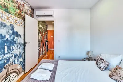 a bedroom with a white bed and a painting on the wall at Campanhã Clock House with terrace in Porto