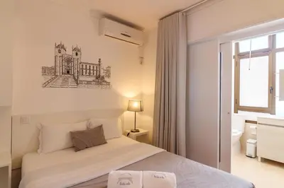 a bedroom with a bed with a drawing on the wall at Lindo Vale Guest House in Porto