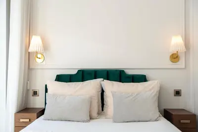 a bed with a green headboard and white pillows at Charming apartment in Cedofeita by Lisbeyond in Porto