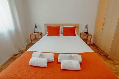 a bedroom with a large white bed with two pillows at Cedofeita Terrace by Hosty in Porto