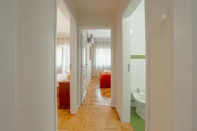 a hallway of a bathroom with a sink and a toilet at Cedofeita Terrace by Hosty in Porto