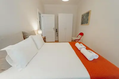 a bedroom with a large white bed with towels on it at Cedofeita Terrace by Hosty in Porto