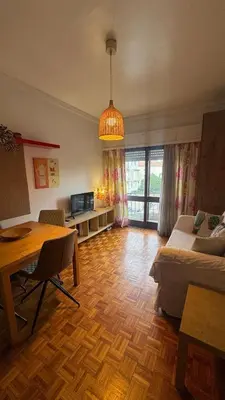 a living room with a bed and a dining table at Covelo in Porto