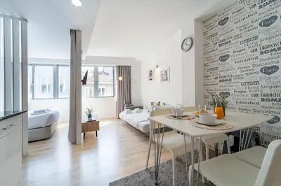 a white living room with a table and a couch at Happy's Apartments in Porto