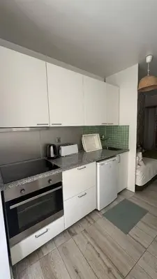 a kitchen with white cabinets and a stove top oven at Apartamento Fontinha in Porto