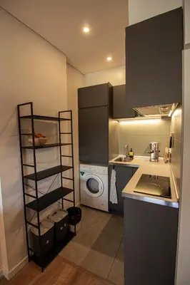 a small kitchen with a washer and dryer at Amy's Place in Porto