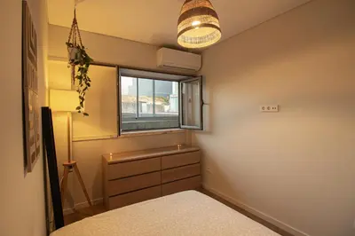 a bedroom with a bed and a window and a dresser at Amy's Place in Porto