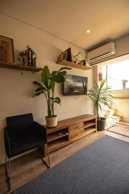 a living room with a black chair and plants at Amy's Place in Porto