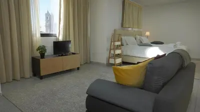 a hotel room with a bed and a couch and a television at Ryamen Inn B in Porto