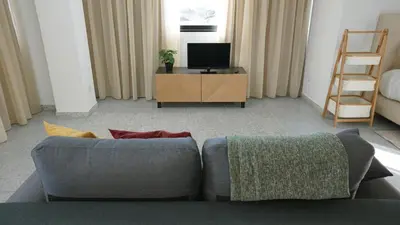 a living room with a couch and a television at Ryamen Inn B in Porto