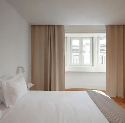 a bedroom with a white bed and a window at Santa Catarina 555 T4 in Porto