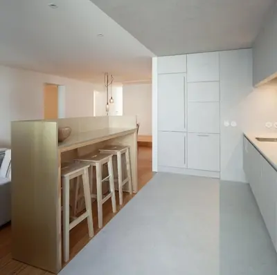 a kitchen with white cabinets and a large island with bar stools at Santa Catarina 555 T4 in Porto