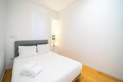 a white bed in a white room with white sheets at Groovy Porto by Upperground in Porto