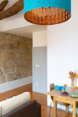 a living room with a table and a stone wall at Groovy Porto by Upperground in Porto