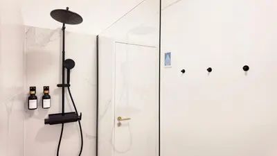 a shower in a bathroom with a glass door at Green House Apartamento Espaçoso e Central in Porto
