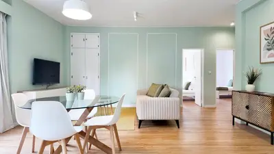 a living room with a glass table and white chairs at Green House Apartamento Espaçoso e Central in Porto