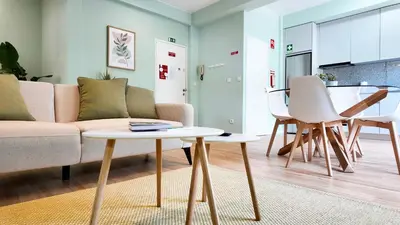 a kitchen with white cabinets and a washer and dryer at Green House Apartamento Espaçoso e Central in Porto