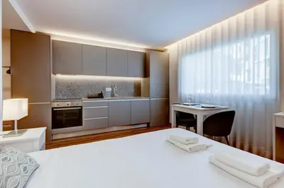 a bedroom with a large white bed and a desk at Blue Hotel Oporto in Porto