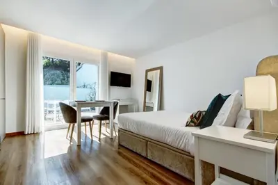 a hotel room with a bed and a desk and a window at Blue Hotel Oporto in Porto