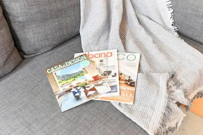 a magazine sitting on top of a couch at Boavista Residence T3 in Porto