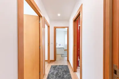 a hallway with doors and a rug on the floor at Boavista Residence T3 in Porto