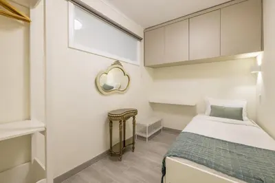 a small bedroom with a bed and a mirror at D&S - Torne 187 in Vila Nova de Gaia
