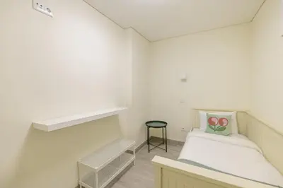 a small white room with a bed and a stool at D&S - Torne 187 in Vila Nova de Gaia