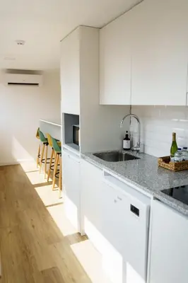 a kitchen with white cabinets and a counter top at Lighthouse by MyMoradia I Vue & Élégance à Porto in Porto