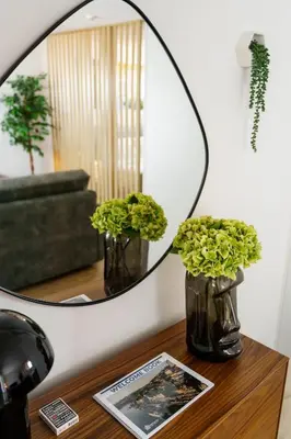 a mirror on top of a table with two vases at Lighthouse by MyMoradia I Vue & Élégance à Porto in Porto
