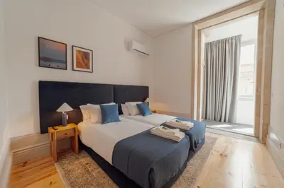 a bedroom with a large bed and a large window at Heart of Porto Apartments by Vacationy in Porto