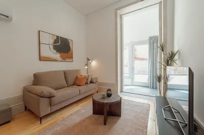 a living room with a couch and a large window at Heart of Porto Apartments by Vacationy in Porto