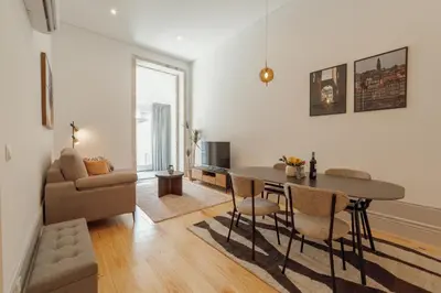 a living room with a table and chairs and a couch at Heart of Porto Apartments by Vacationy in Porto