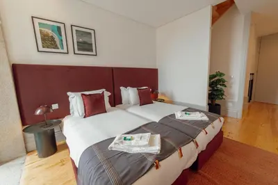 a hotel room with a large bed with two towels on it at Heart of Porto Apartments by Vacationy in Porto
