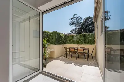 a sliding glass door leading to a patio with a table and chairs at Terraced Apartment in the Heart of Porto - Free Parking in Porto