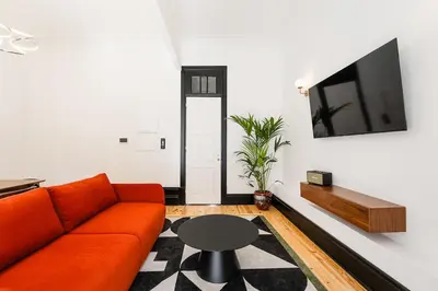 a living room with a orange couch and a table at Terraced Apartment in the Heart of Porto - Free Parking in Porto