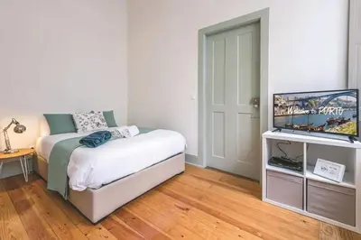 a bedroom with a bed and a flat screen tv at Porto Inlapa Studio RC in Porto