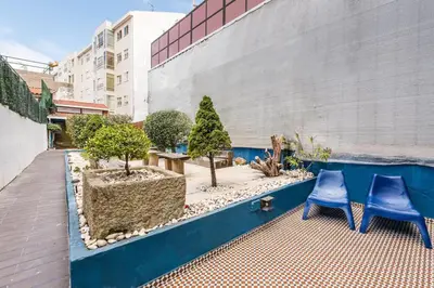 a patio with two blue chairs and trees on it at Porto Inlapa Studio RC in Porto